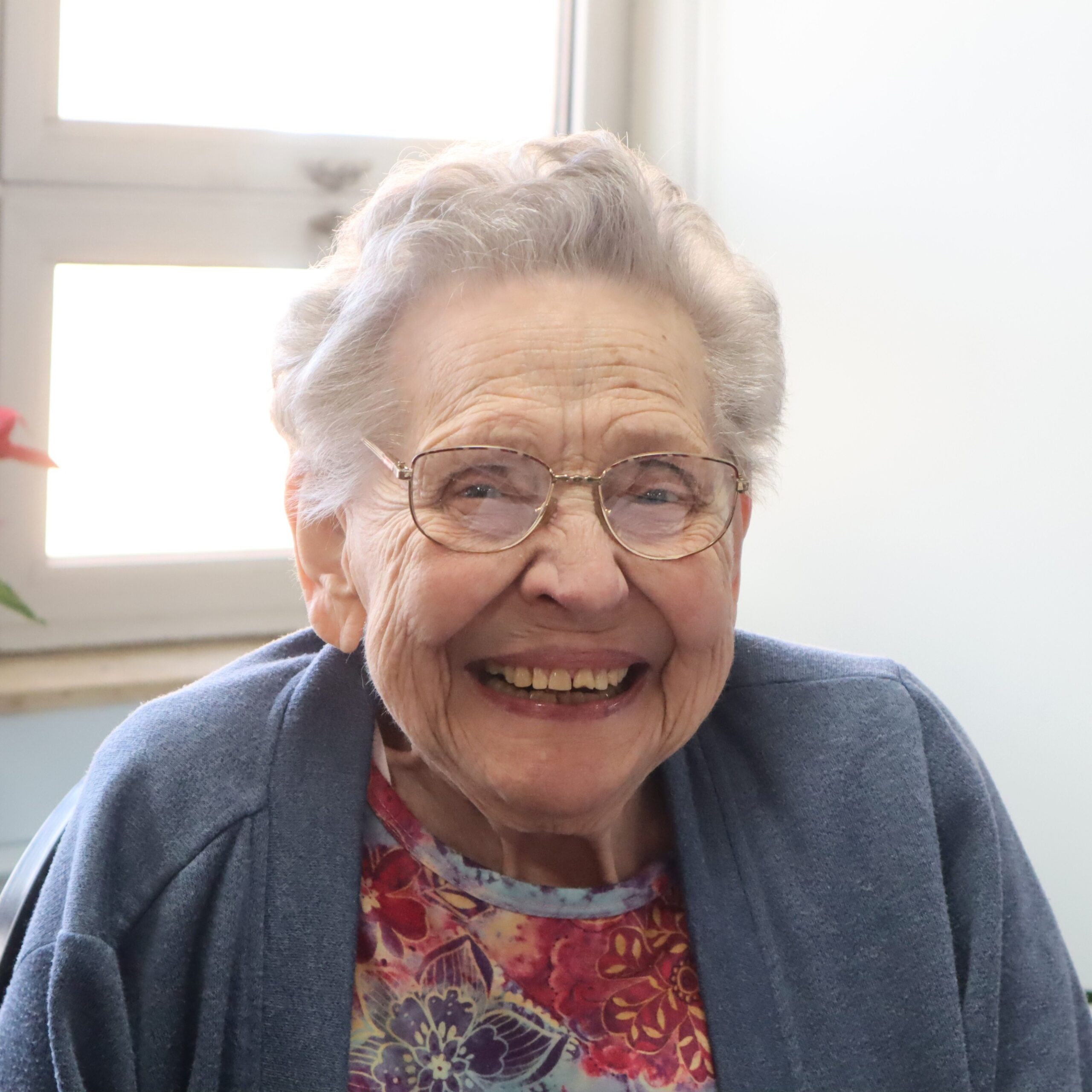 A female resident with glasses smiling.