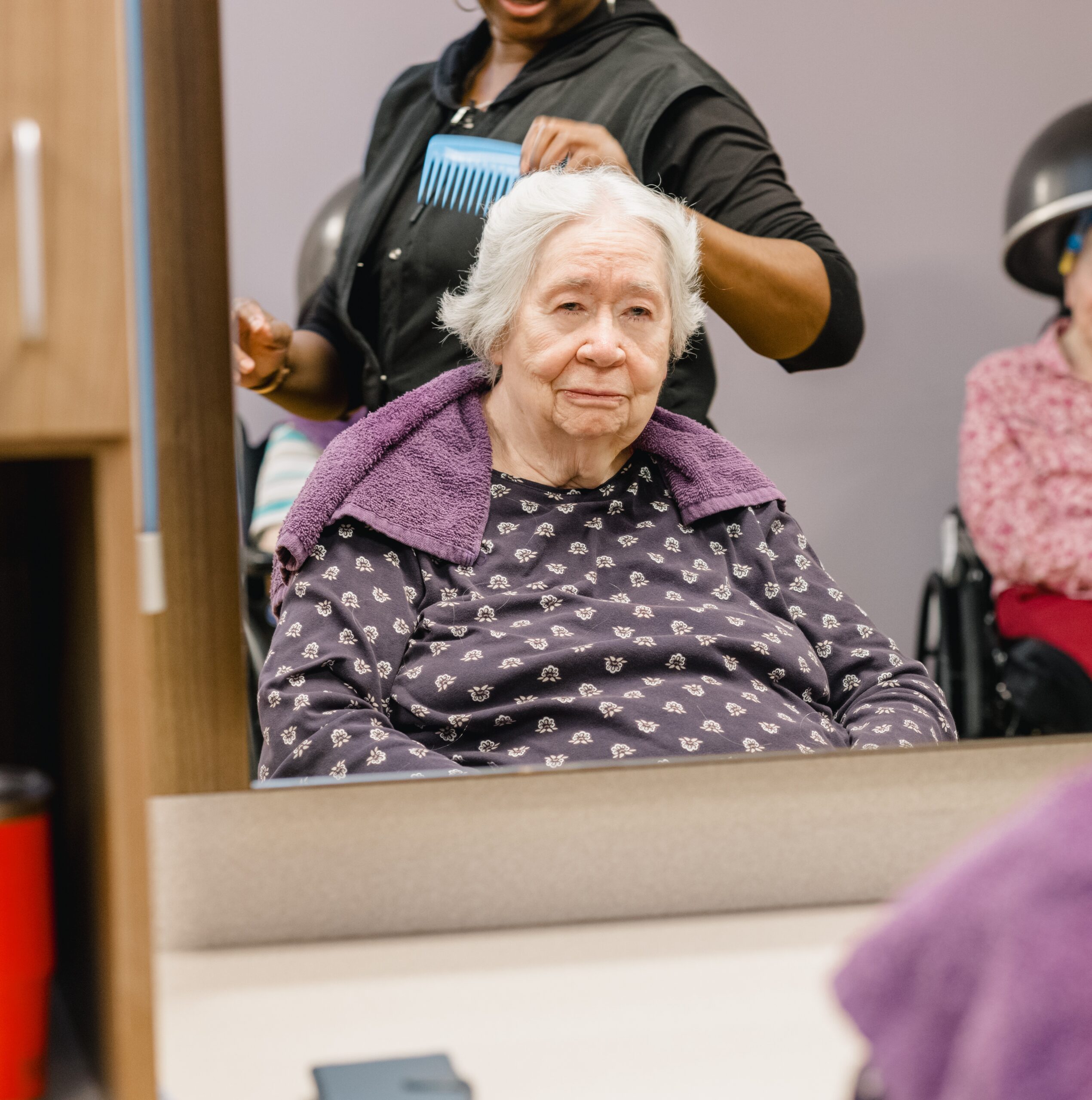 A resident in the beauty shop getting her hair done.