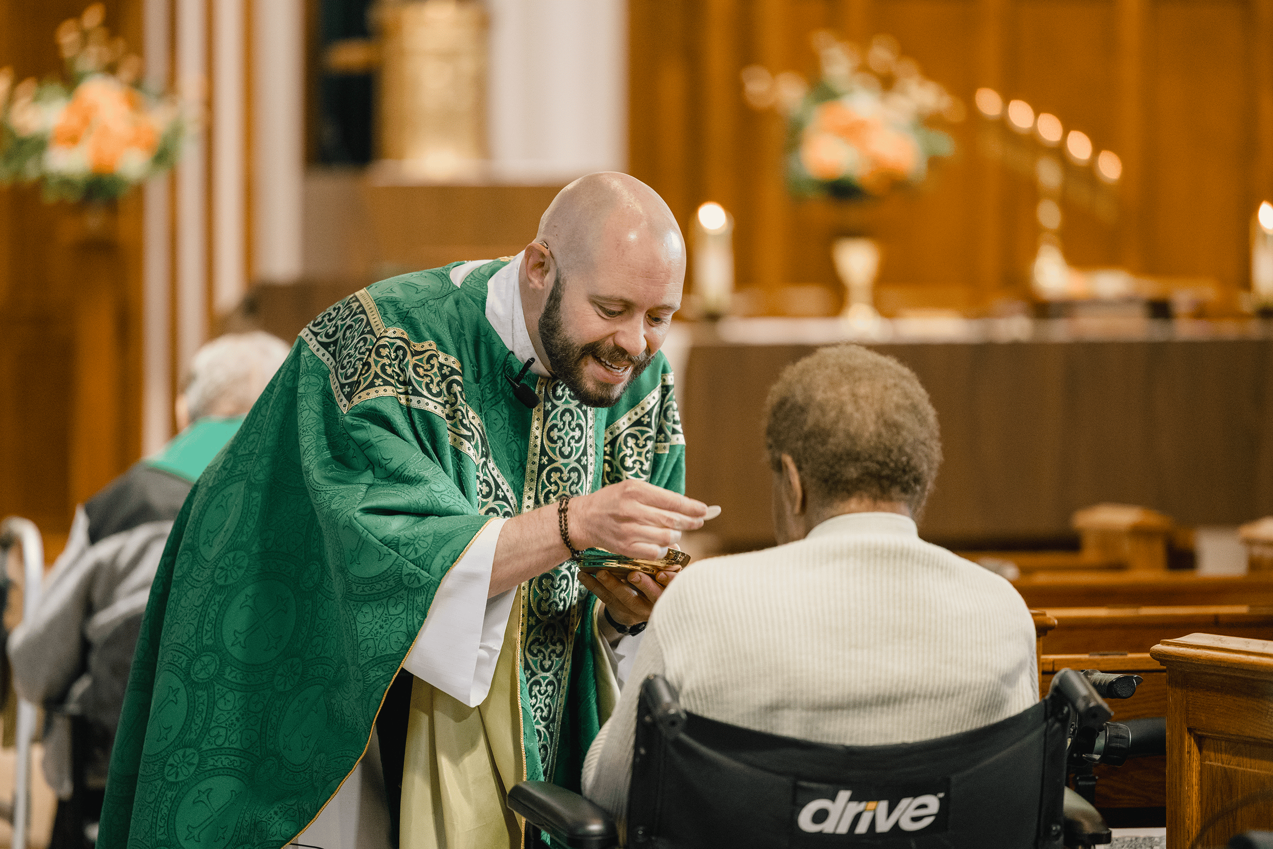 Father Dan distributing communion to a resident in the chapel
