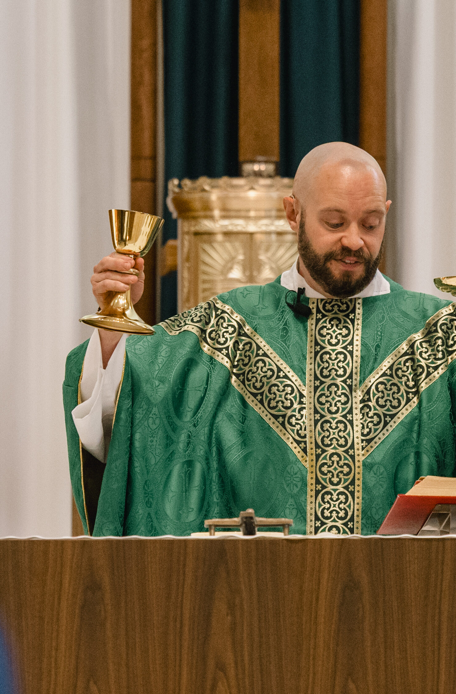 A priest holding the body and blood with residents in the congregation